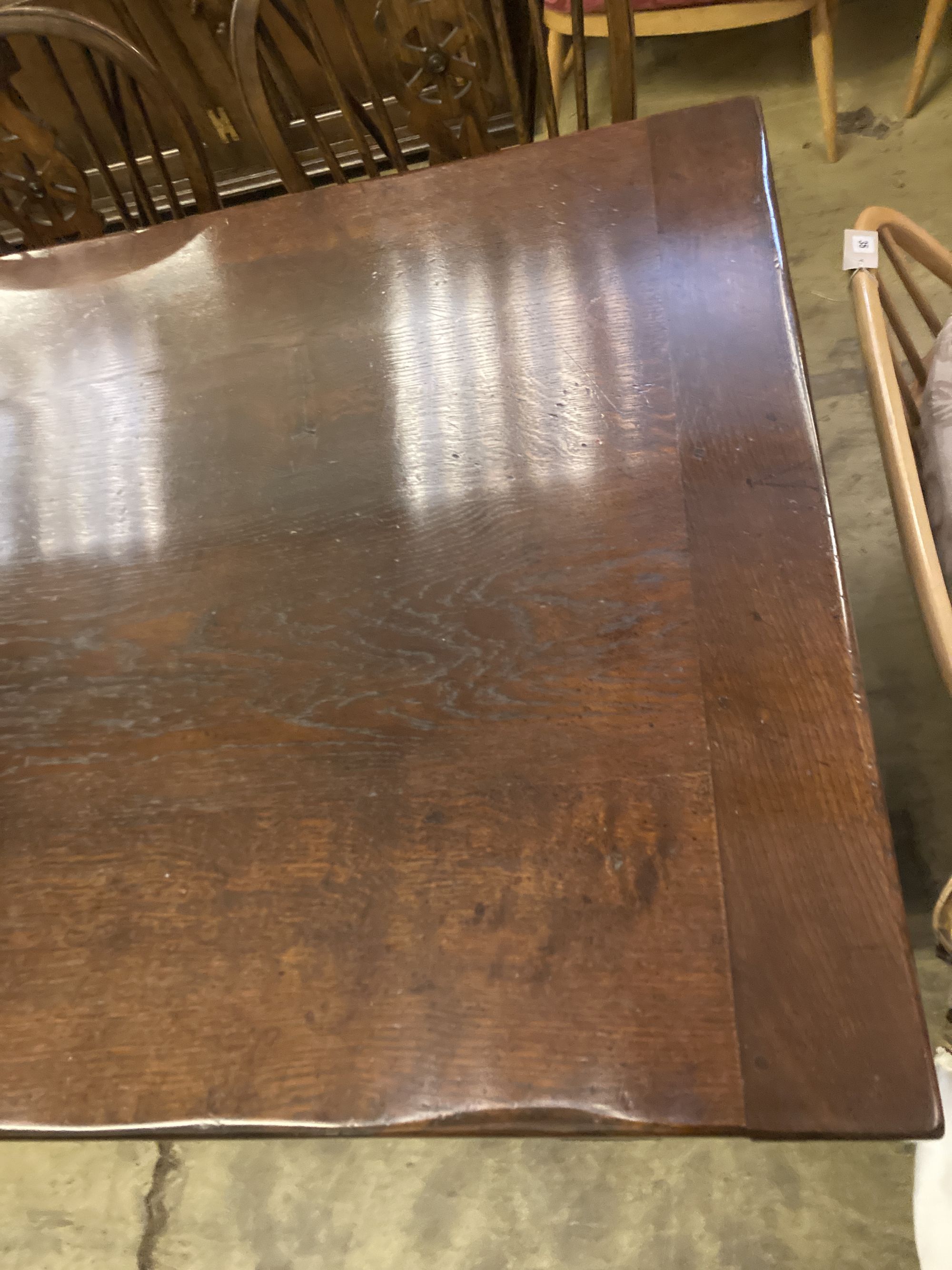 An 18th century style oak refectory table having planked top on double turned end supports, width 230cm depth 90cm height 76cm